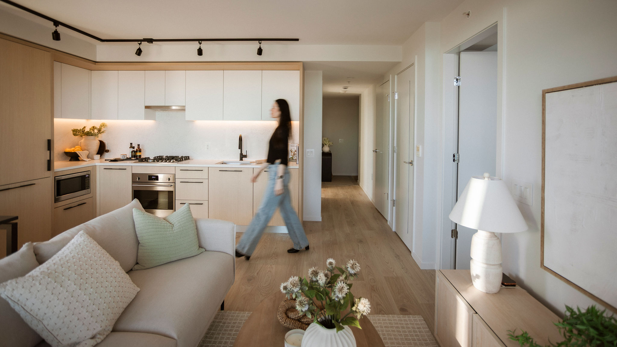Open-concept condo with modern kitchen, living area, and hallway in East Vancouver
