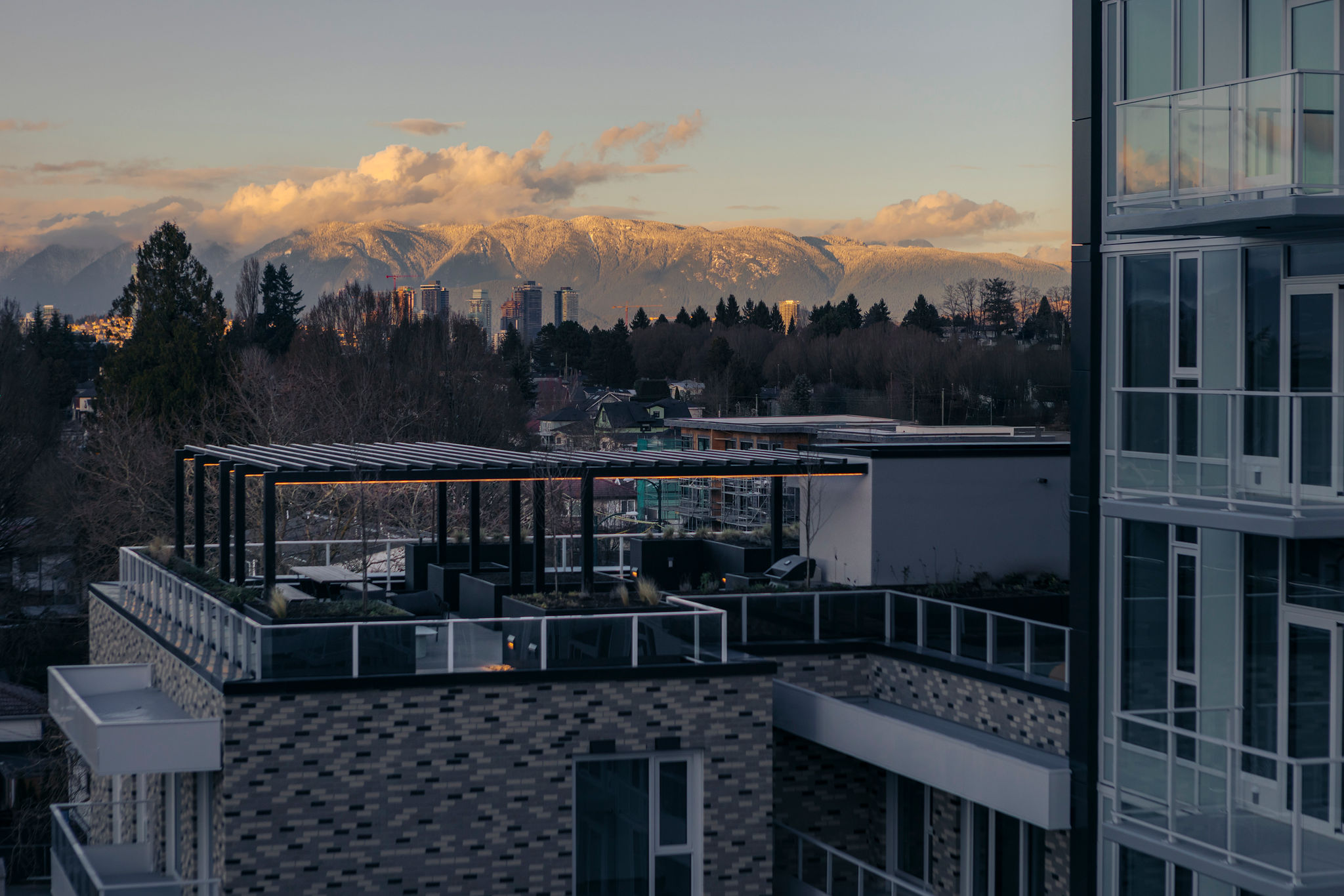 Rooftop terrace with lounge area and mountain views at modern East Vancouver condo