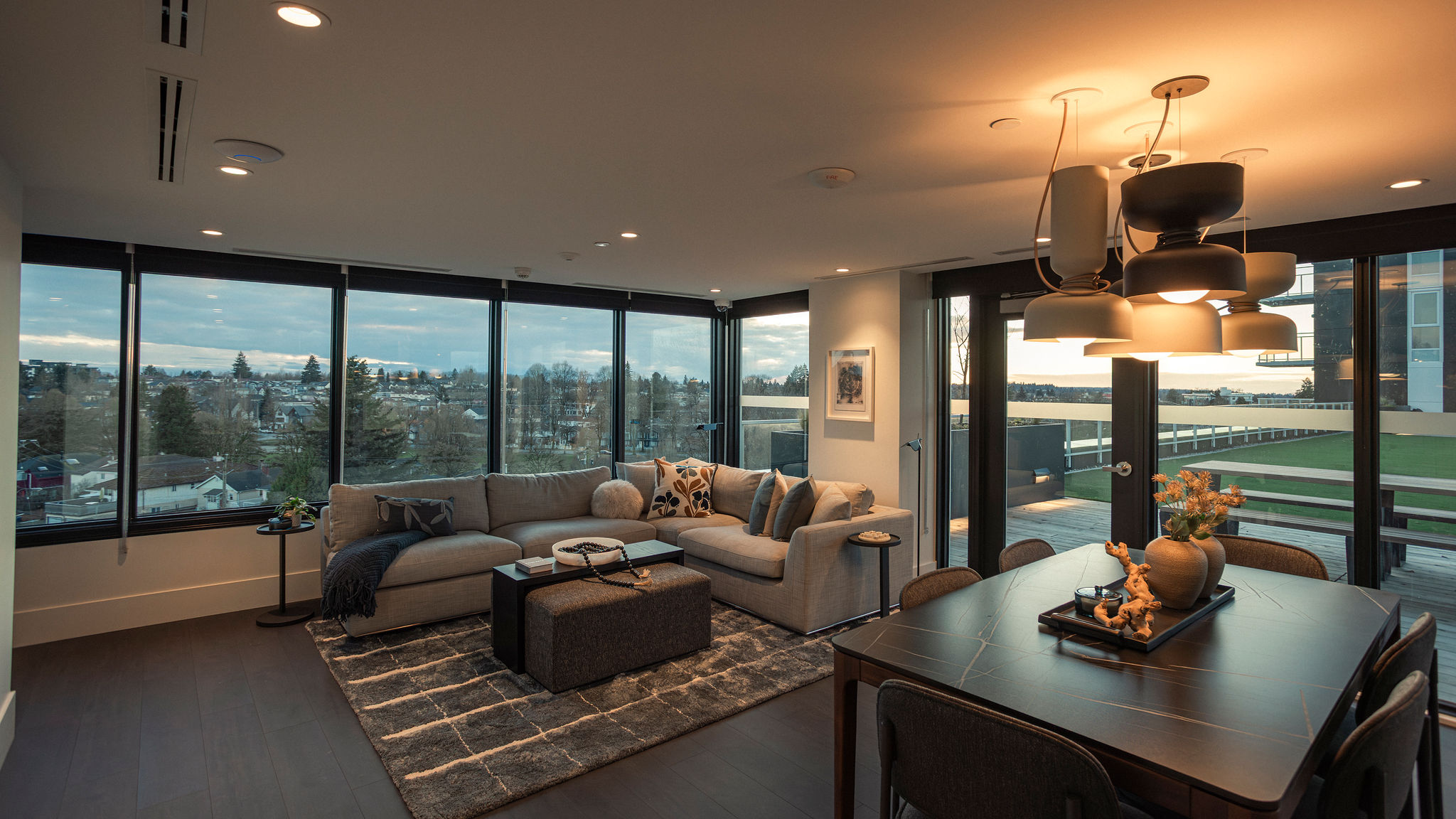Entertainment lounge with floor-to-ceiling windows, seating area, and dining space in East Vancouver condo