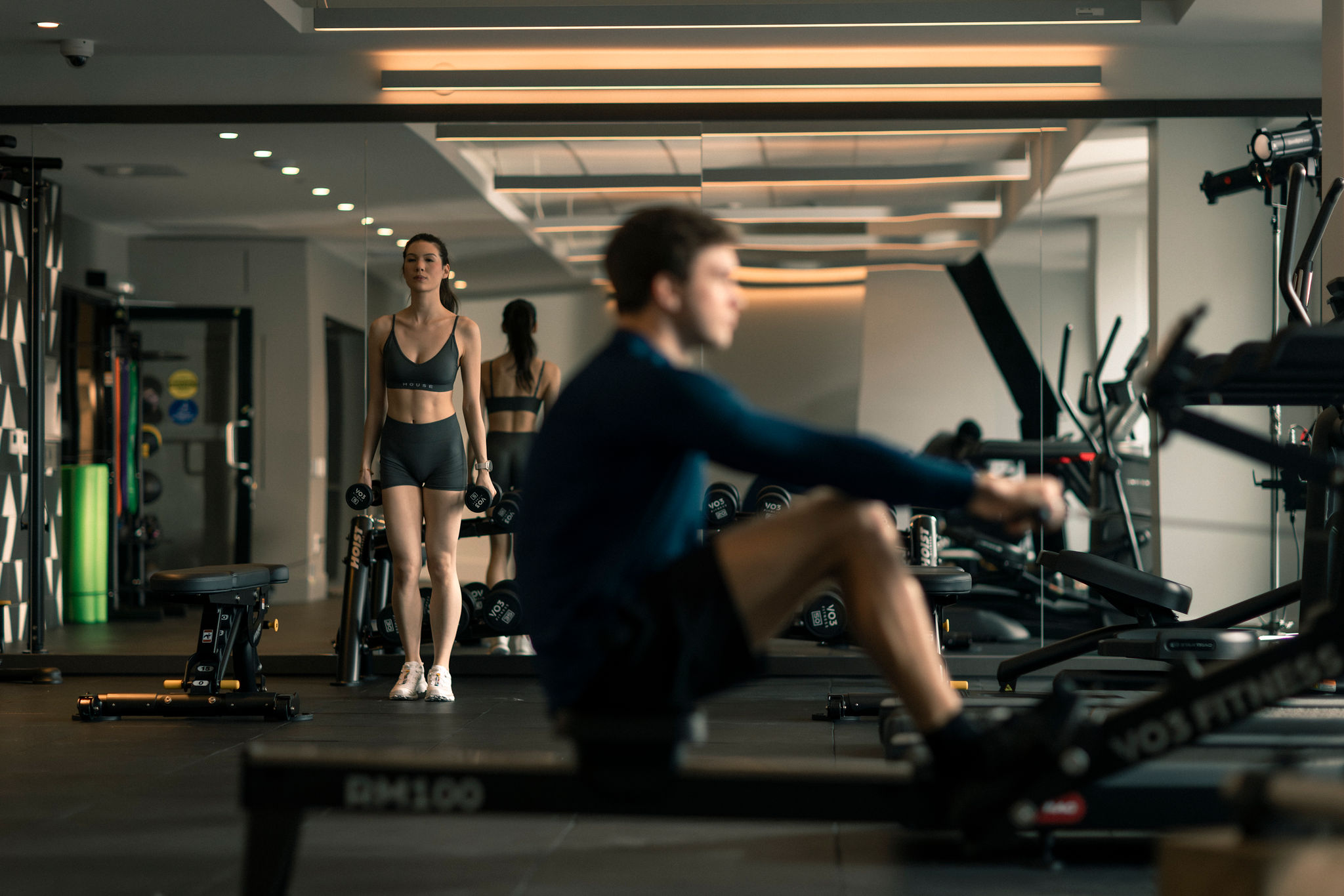 Modern condo fitness centre at Frame with rowing machine, strength equipment, and residents working out