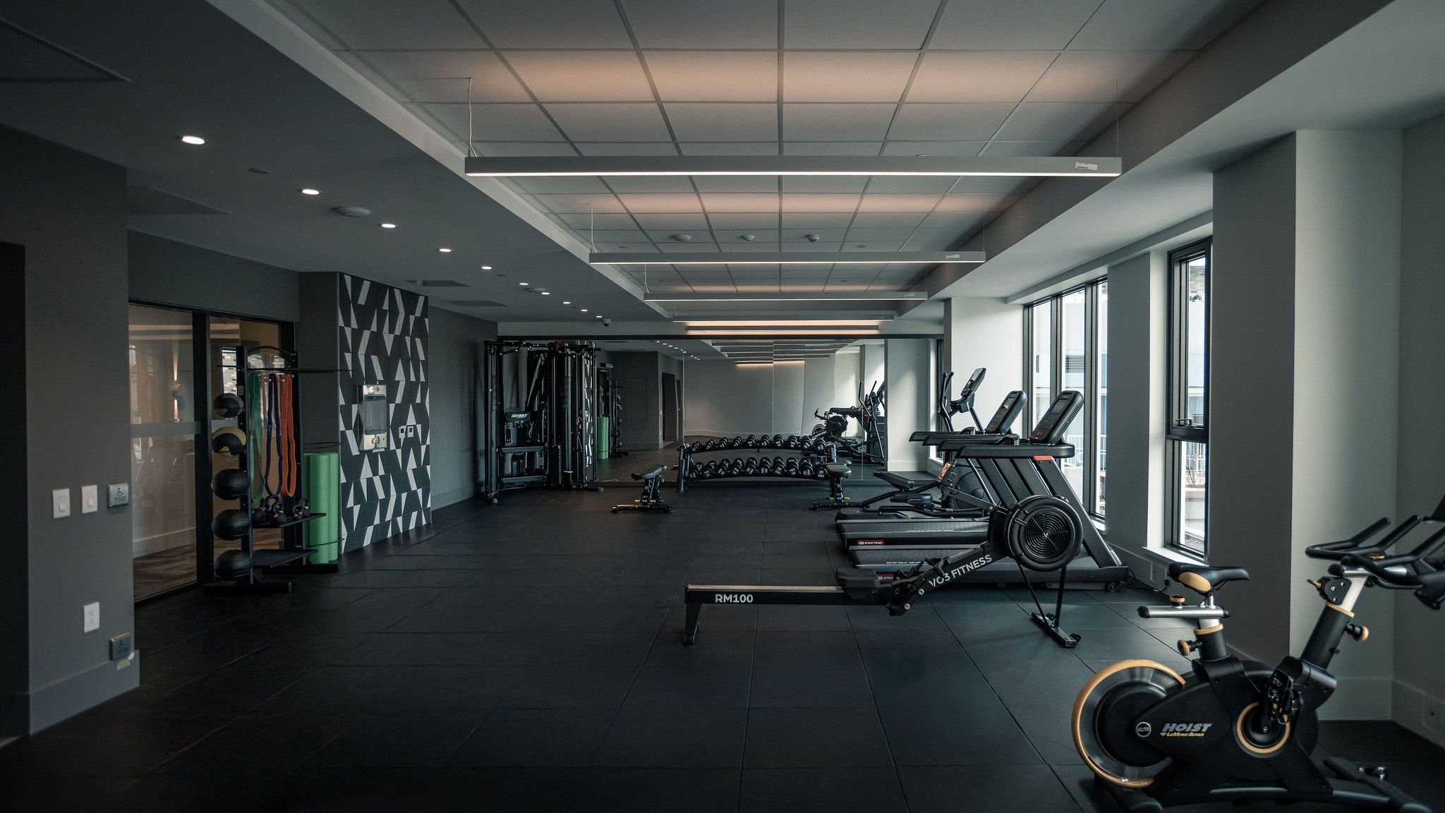 Spacious condo fitness centre with cardio machines, weights, and modern design in East Vancouver